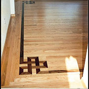 Knot accent with log cabin border, flush floor vent in private residence. Mountain Lake, SC