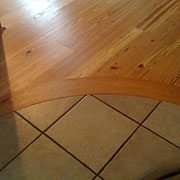 All Wood Floorcraft shop made BENT heart pine header to tile, private 		residence, Hickory, NC
